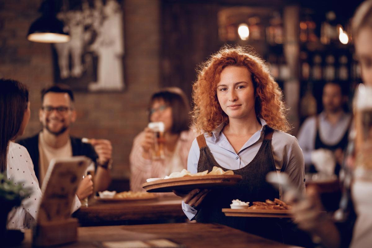waitress holding two plates of food 