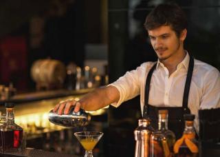 bartender pouring cocktail in glass